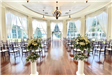 View from the back of an indoor wedding set up in front of large window