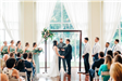 Indoor wedding ceremony in front of a large window