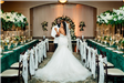 Bride and groom in between two long tables