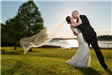 Bride and groom kissing in front of lake