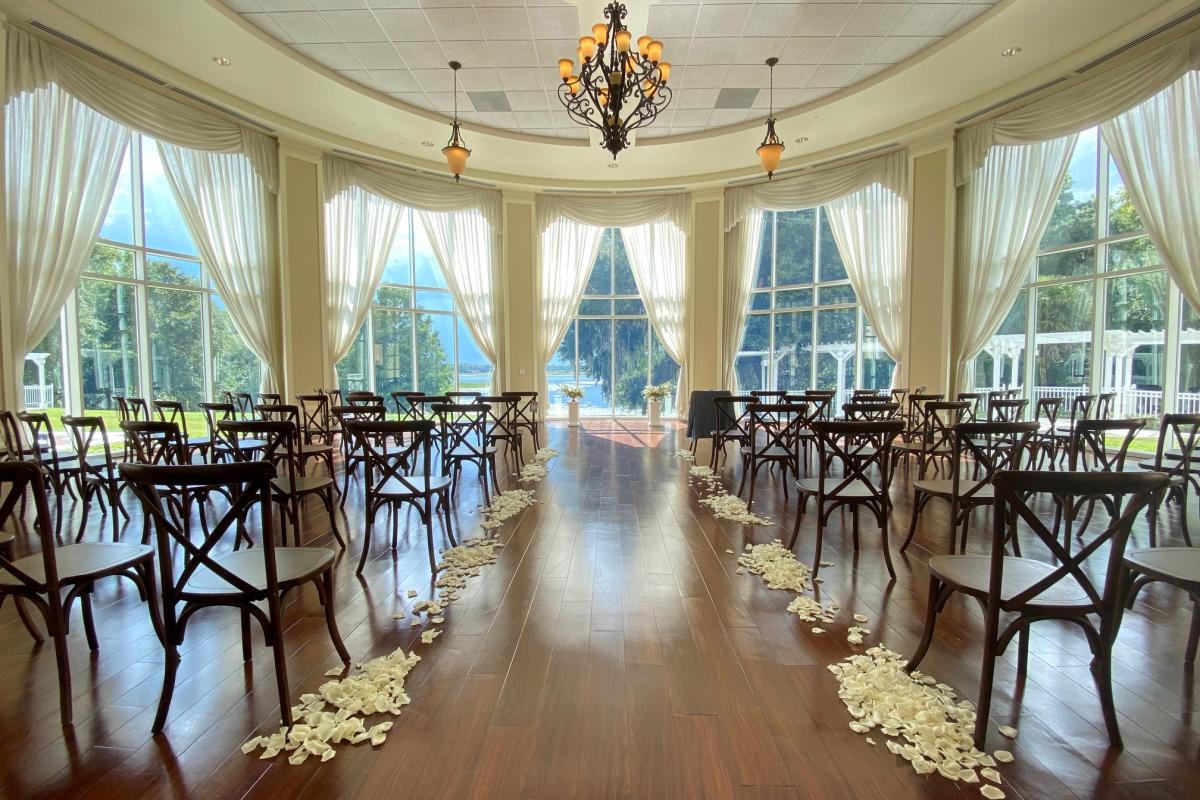 View from the back of an indoor wedding set up in front of large window